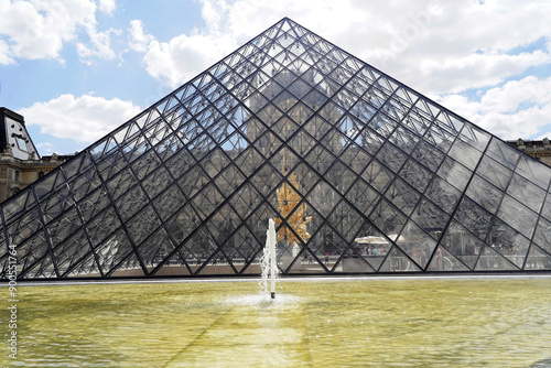 Glaspyramide im Innenhof des Palais du Louvre, Paris, Frankreich, Europa, Menschen laufen zwischen den Gebäuden und der Glaspyramide des Louvre in Paris bei sonnigem Wetter, Europa