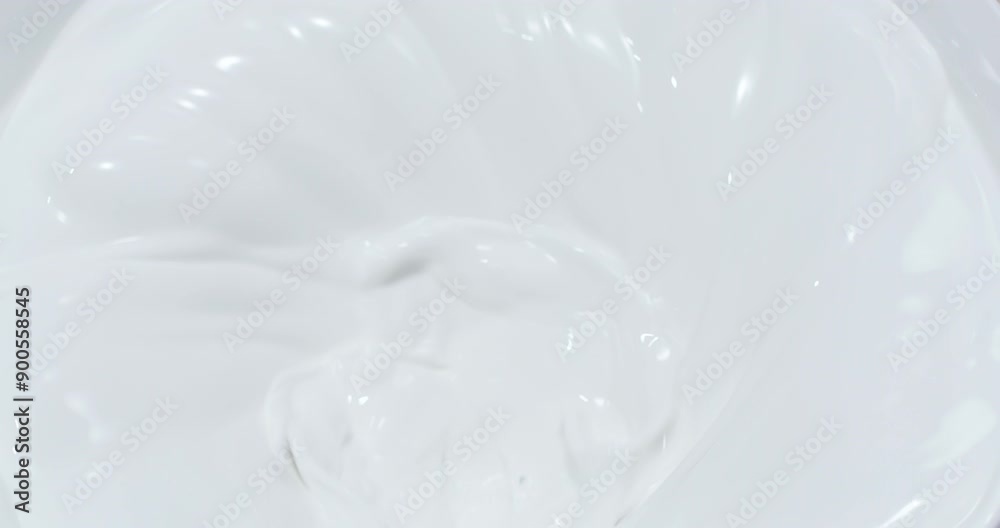 Whipping white milk cream, top view. Whipping white milk cream, top view.