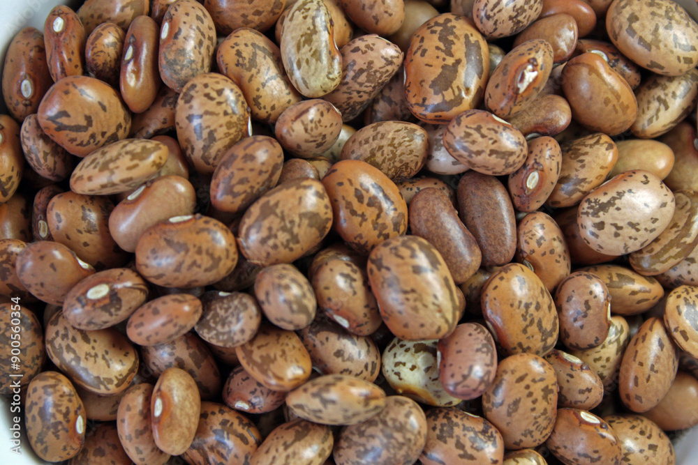Bountiful pile of nutritious pinto beans forms a richly textured background, showcasing these healthy legumes in all their natural glory Bountiful pile of nutritious pinto beans forms a richly textured background, showcasing these healthy legumes in all their natural glory