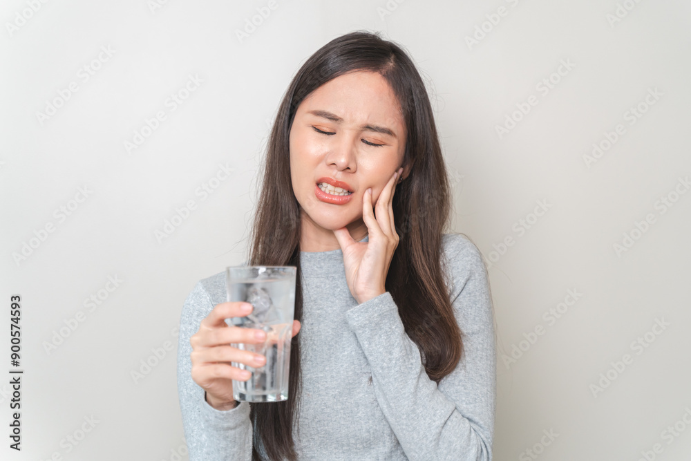 Face expression suffering from sensitive teeth, Asian young woman touching cheek Face expression suffering from sensitive teeth, Asian young woman touching cheek