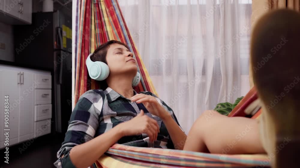 woman enjoying music in her headphones dancing and enjoying herself in her apartment woman enjoying music in her headphones dancing and enjoying herself in her apartment