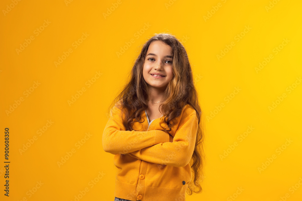 Smiling kid girl looking at camera over yellow background. Childhood and positive emotions concept Smiling kid girl looking at camera over yellow background. Childhood and positive emotions concept