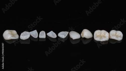 ceramic dental crowns and veneers on black glass with reflection