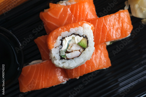 Sushi rolls with salmon, cucumber and avocado, top view, close-up, selective focus