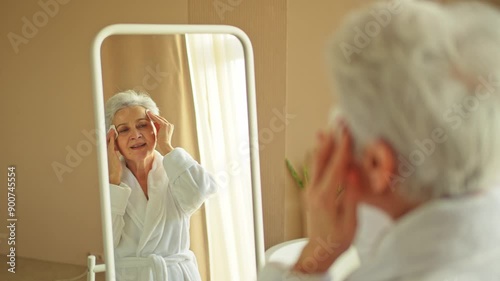 Love yourself. Beautiful old woman enjoying mirror reflection. Senior older lady spending morning in bathroom looking at mirror confident happy. Woman doing daily morning beauty routine. Self love