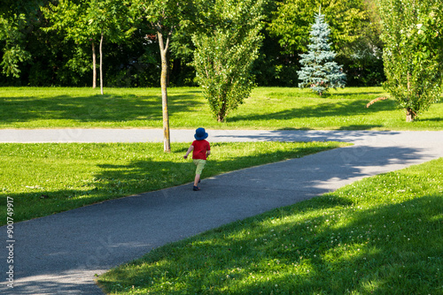 Obraz na plátne Back view of unattended small child running away in park alley during a summer a