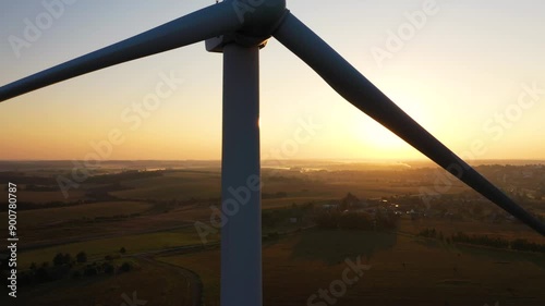 The large windmill is backlit early in the morning. Alternative renewable energy concept