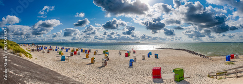 Panoramablick über den menschenleeren Strand von Utersum auf der Nordseeinsle Föhr mit Strandkörben bei aufgelockerter Bewölkung
