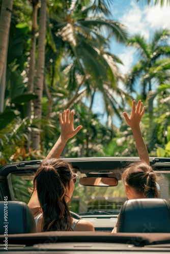 two women in a convertible car with their hands up in the air photo