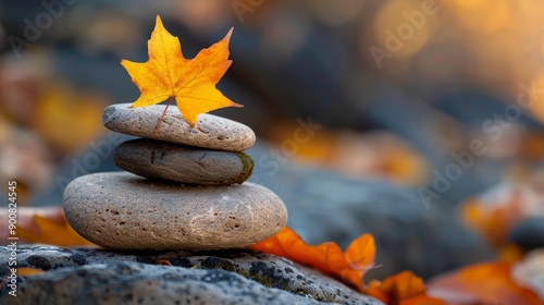 Stack of smooth pebbles with autumn leaf