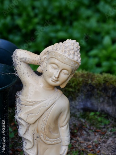 Nepalesische Figur auf de Ohlsdorfer Friedhof lehnt an Vase photo