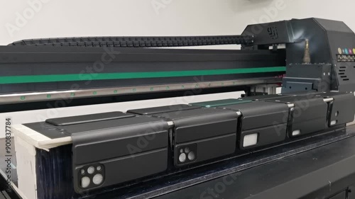 A modern digital large-format UV printer prints images on smartphone cases. UV pinning is the process of applying a dose of low intensity ultraviolet light to a UV curable ink