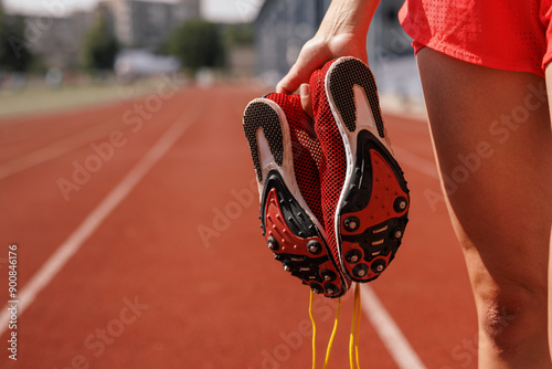 Fototapeta Naklejka Na Ścianę i Meble -  Red Athletic Shoes on Running Track