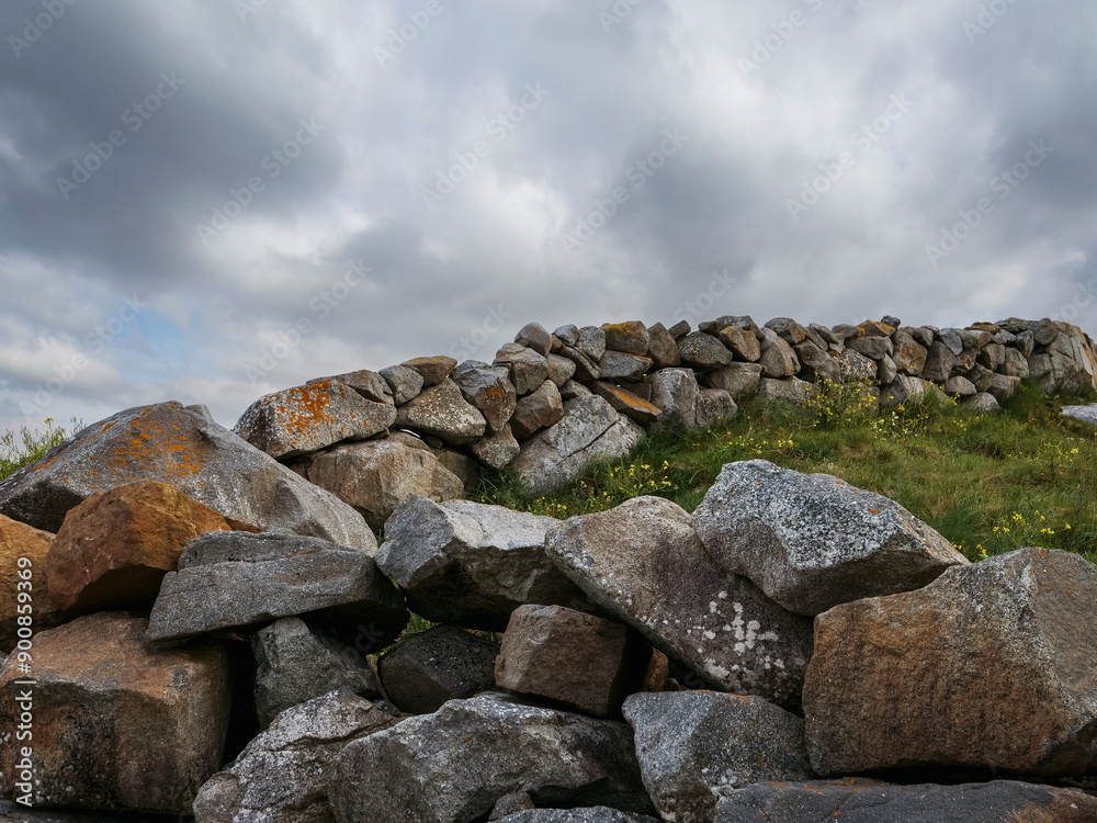 Stone fence and green field, blue cloudy sky background. Rural Ireland. Irish landscape. Old craft and skill example. Stone fence and green field, blue cloudy sky background. Rural Ireland. Irish landscape. Old craft and skill example.