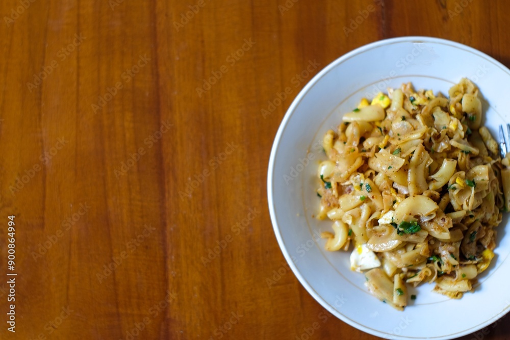 Stir fried spicy macaroni on white platree with fork, in the wood table, homemade food. Stir fried spicy macaroni on white platree with fork, in the wood table, homemade food.