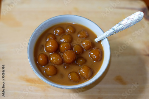 Biji salak or bubur candil is Indonesian porridge of sweet potato balls in palm sugar syrup and coconut milk sauce on the table . Very popular during Ramadan. photo