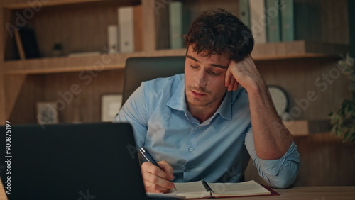 Tired student video calling by laptop in dark apartment closeup. Unmotivated man photo