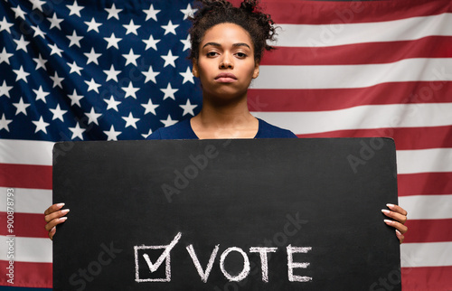 Presidential elections 2020 in USA. Black woman holding Vote sign against american flag photo