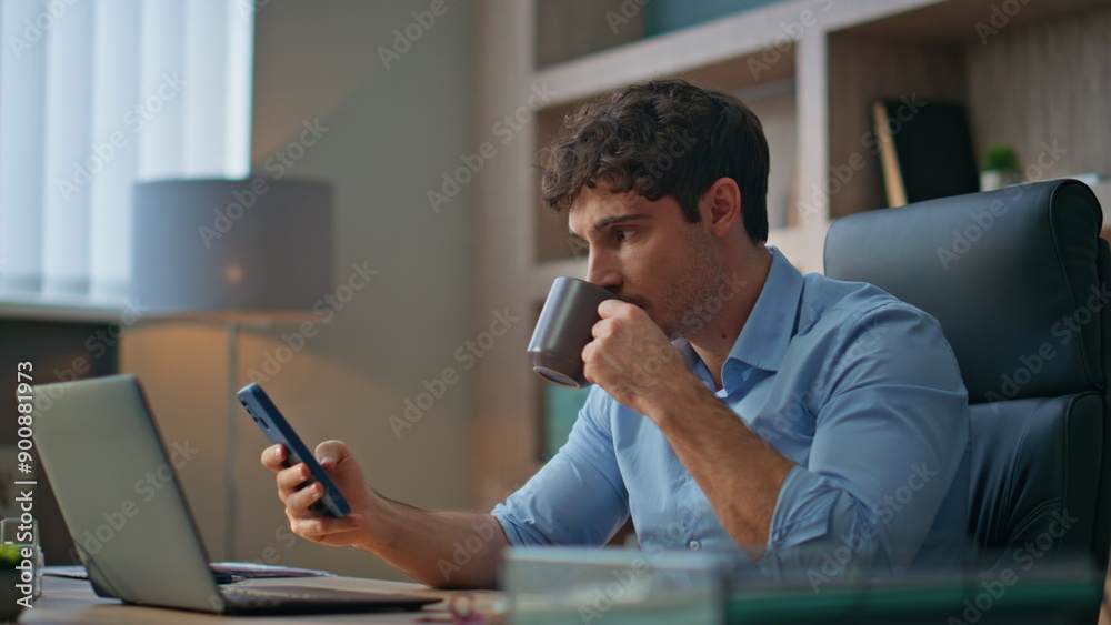 Office manager using mobile phone in morning. Closeup boss rest drinking coffee Office manager using mobile phone in morning. Closeup boss rest drinking coffee