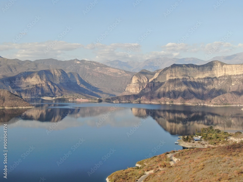 lake in the mountains during sunset and an old dam in the distance, seen from a drone. lake in the mountains during sunset and an old dam in the distance, seen from a drone.