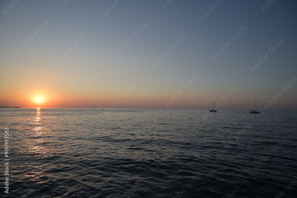 imbarcazione a vela naviga in mezzo al mare al tramonto imbarcazione a vela naviga in mezzo al mare al tramonto