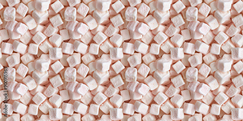 A cute and dreamy background of close-up of soft cube shaped soft ivory marshmallows, each piece showcasing its fluffy and powderly texture and light sugar coating photo