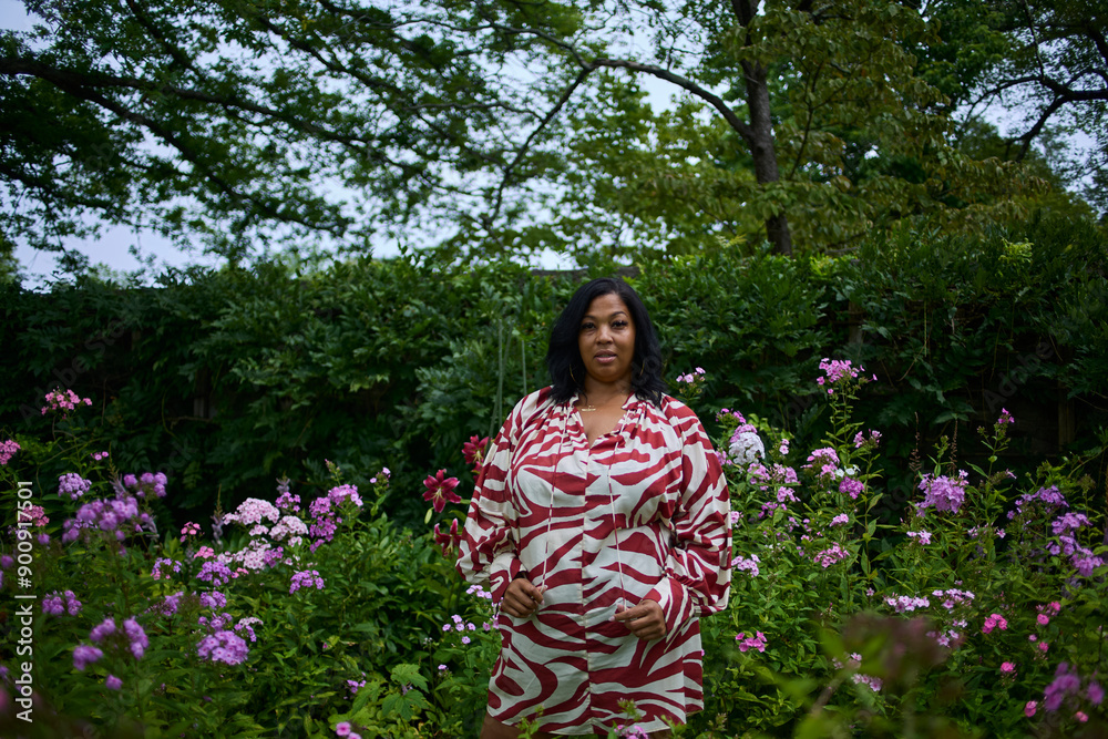Portrait of a woman in a lush green park on a summer day surrounded by flowers. Portrait of a woman in a lush green park on a summer day surrounded by flowers.