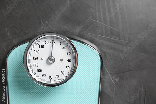 One bathroom scale on grey textured background, top view. Space for text