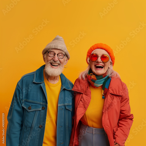 Crazy smiling senior couple, isolated yellow color background, image with space for text / Couple de personnes âgées souriantes et folles, fond de couleur jaune isolé, image avec espace pour le texte