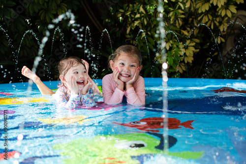 Happy children in a pool. Happy childhood concept. Laughing kids enjoying summer at the splash pad