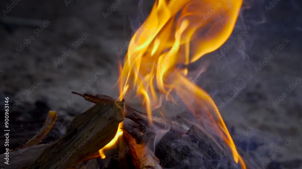 Slow motion close-up of a campfire in the evening, capturing flames and smoke. Slow motion close-up of a campfire in the evening, capturing flames and smoke.