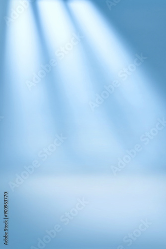 Spotlights illuminate empty stage blue background.