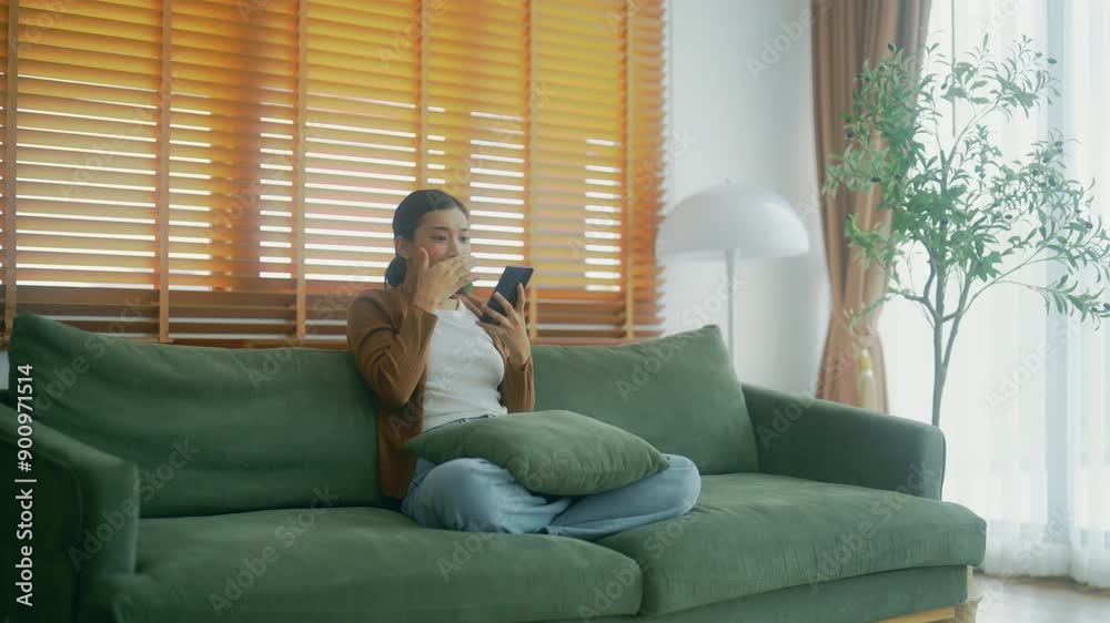 Happy young asian woman relax on comfortable couch at home texting messaging on smartphone, smiling girl use cellphone, chatting online message, shopping online from home Happy young asian woman relax on comfortable couch at home texting messaging on smartphone, smiling girl use cellphone, chatting online message, shopping online from home