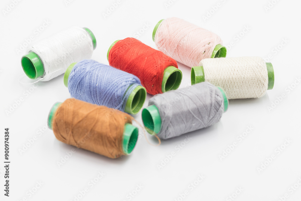 Colorful Spool of sewing thread, spool of industrial threads, Colored spools of thread on a white background. Colorful Spool of sewing thread, spool of industrial threads, Colored spools of thread on a white background.
