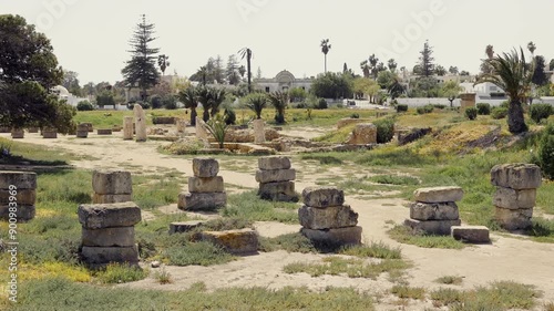 Scenic view of ruins of ancient Carthage Punic Ports with remains of stone structures and dry docks overgrown with lush greenery under clear sky. Archaeological site of Tunisia. High quality 4k