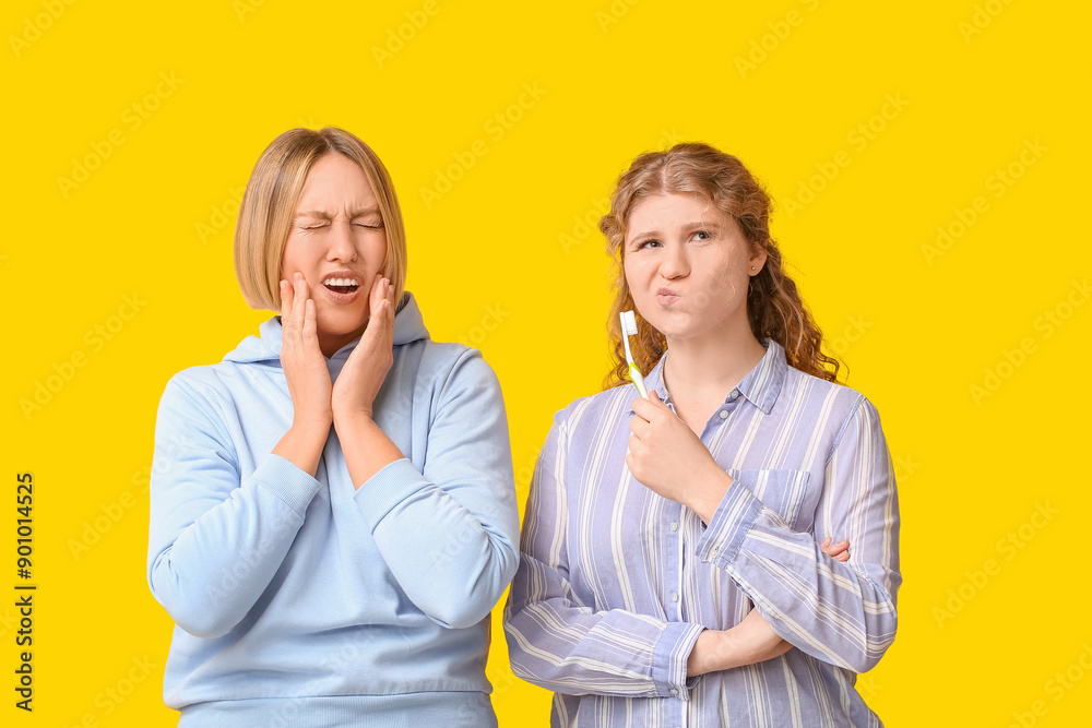 Beautiful women with teeth brush suffering from toothache on yellow background Beautiful women with teeth brush suffering from toothache on yellow background