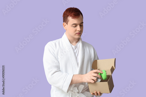 Young man holding box with ...