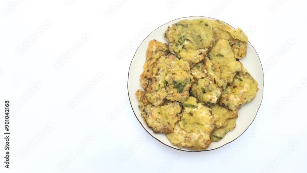 Traditional fried tempeh, or tempeh mendoan, or deep fried tempeh with spiced batter, is one of the most the most popular street foods from Indonesia. Fried tempeh on the plate on the white background Traditional fried tempeh, or tempeh mendoan, or deep fried tempeh with spiced batter, is one of the most the most popular street foods from Indonesia. Fried tempeh on the plate on the white background
