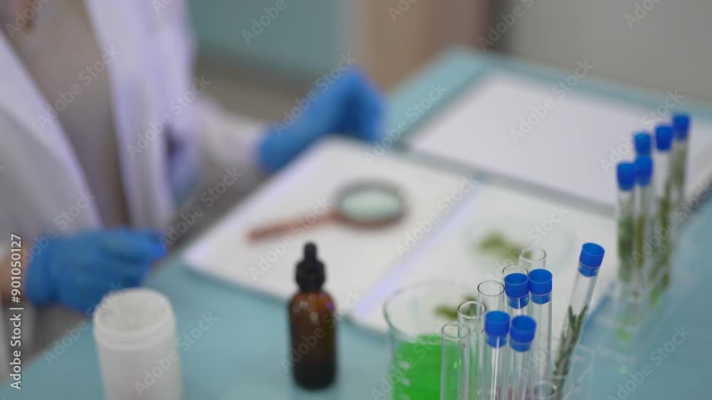 scientists perform experiments and record data. people arranges equipment with test tubes and chemicals for producing medicine and biochemistry. man hold tubes of chemical liquids and plant samples.