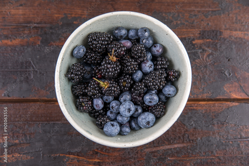 Ripe black blackberries and blue blueberries on a wooden table Ripe black blackberries and blue blueberries on a wooden table