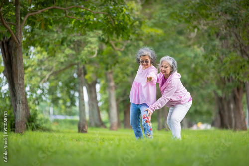 Two Elderly Women Exercising Outdoors in a Tree-Lined Park, Embracing Health and Friendship