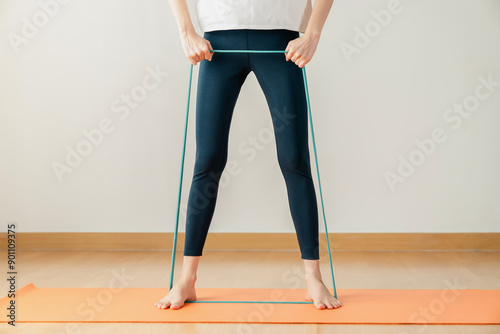 woman is exercising and is pulling on a rubber band to stretch.