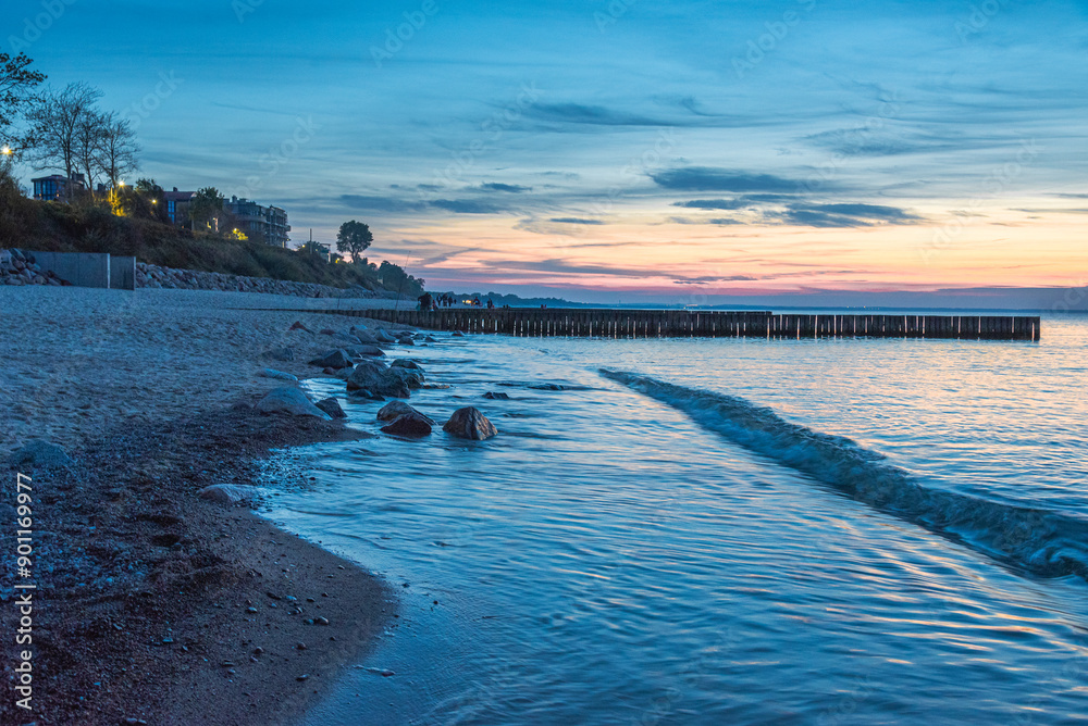 View of sand beach with wooden breakwaters on the Baltic Sea coast on sunset in Zelenogradsk. Russia