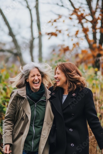 Two middle-aged women laughing and walking in the park
