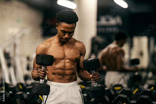 Foto Strong powerful muscular shirtless bodybuilder doing hammer curls at gym