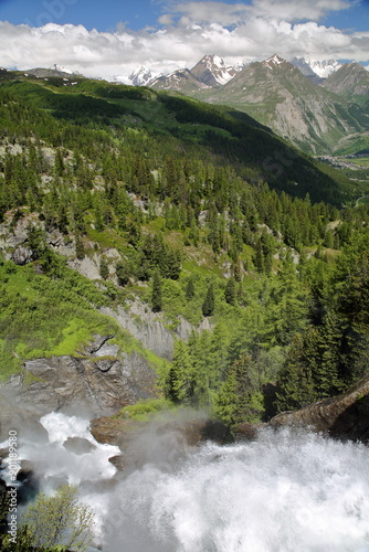 The Rutor waterfalls overlooking the valley towards La Thuile in Italy, Aosta Valley, with high peaks in the background  photo