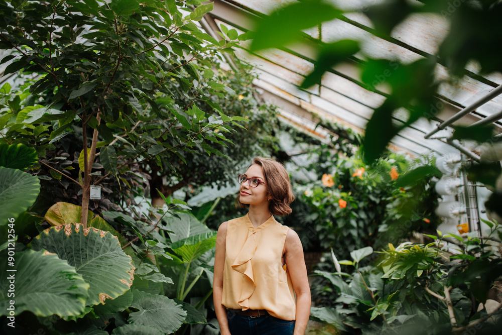 Beautiful woman standing in botanical garden, in the middle of lush green foliage. Beautiful woman standing in botanical garden, in the middle of lush green foliage.