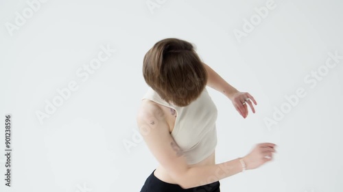 Attractive talented woman dancing in light studio at white background. Graceful female dancing indoors. She moves confidently and purposefully. Contemporary dance. 4K, UHD photo