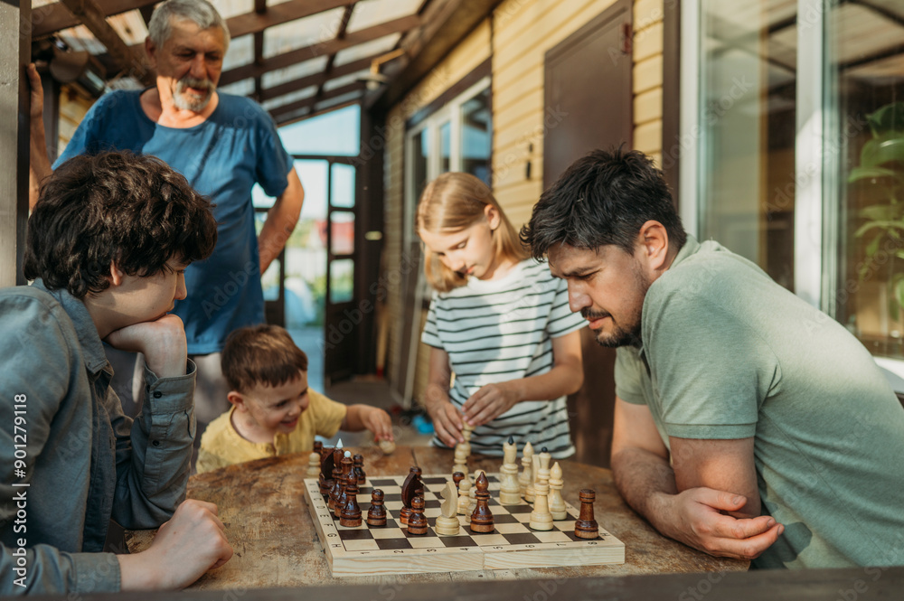 Family members playing chess with each other on porch Family members playing chess with each other on porch