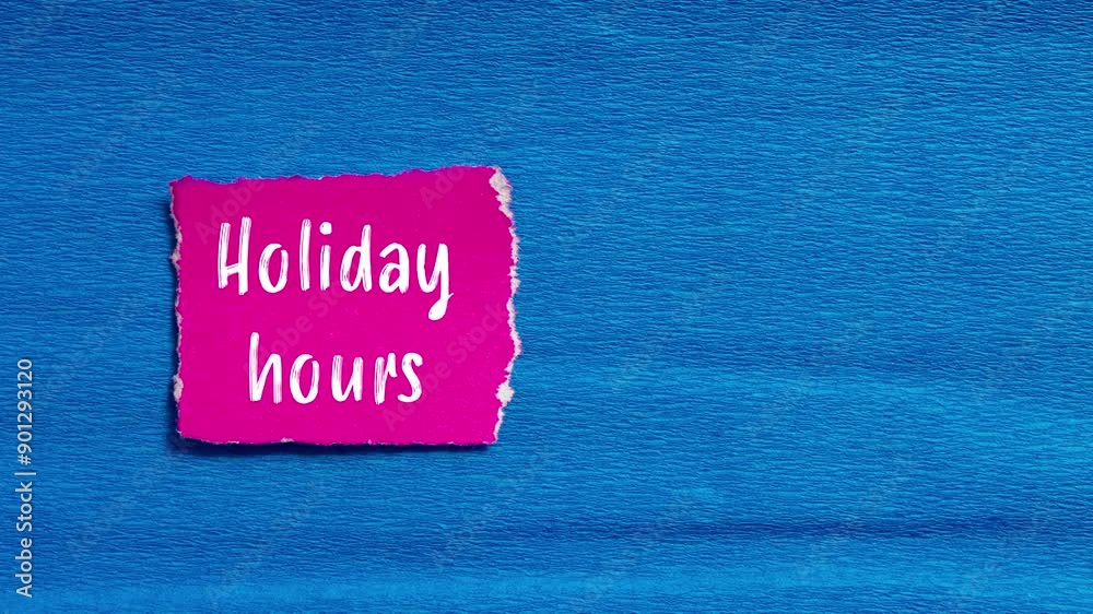 Holiday hours message writing on ripped torn pink paper piece on blue background